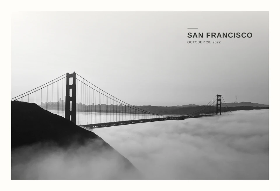 A black-and-white photograph of the Golden Gate Bridge rising above the fog. San Francisco, October 28, 2022.